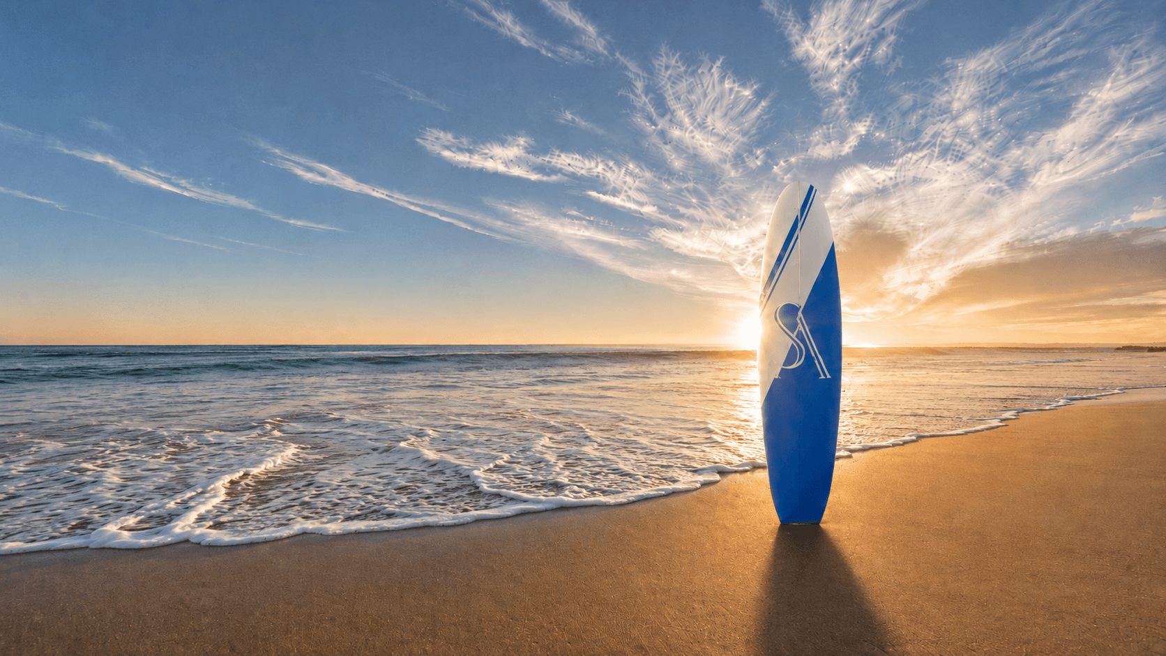 A blue surfboard standing at the beach at sunset